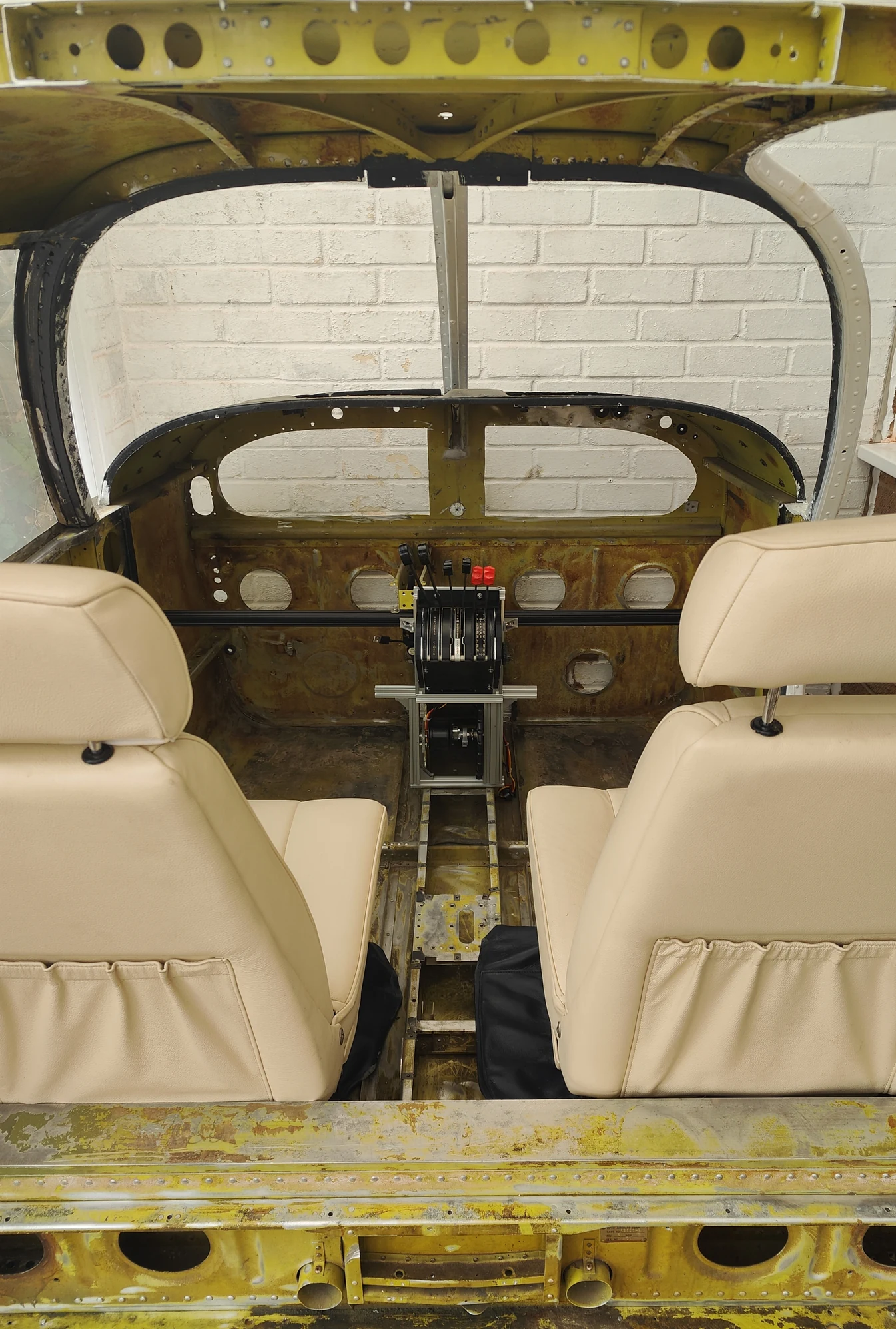 FlightNovo cockpit conversion in progress: exposed real aircraft structure, two seats and a central throttle pedestal
